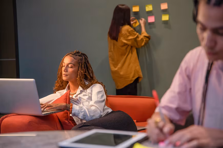 Team members working together in an office with sticky notes on the wall